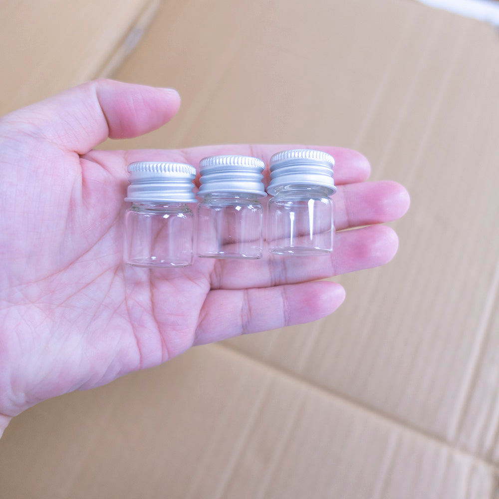 Doorzichtige glazen flessen met zilverkleurige doppen