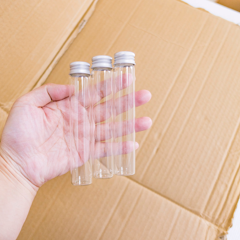 Doorzichtige glazen flessen met zilverkleurige doppen