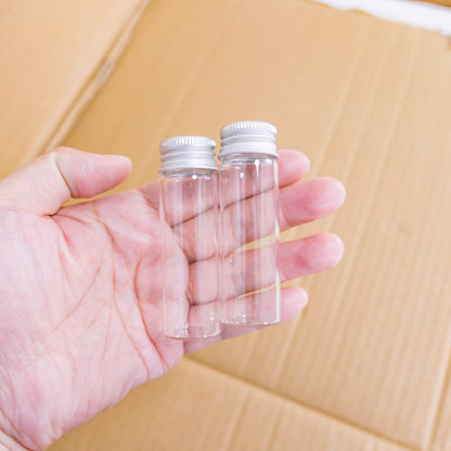 Doorzichtige glazen flessen met zilverkleurige doppen
